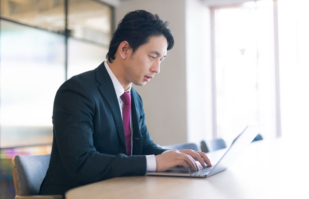 ノートパソコンで新NISA口座の開設手続きを進める会社員男性